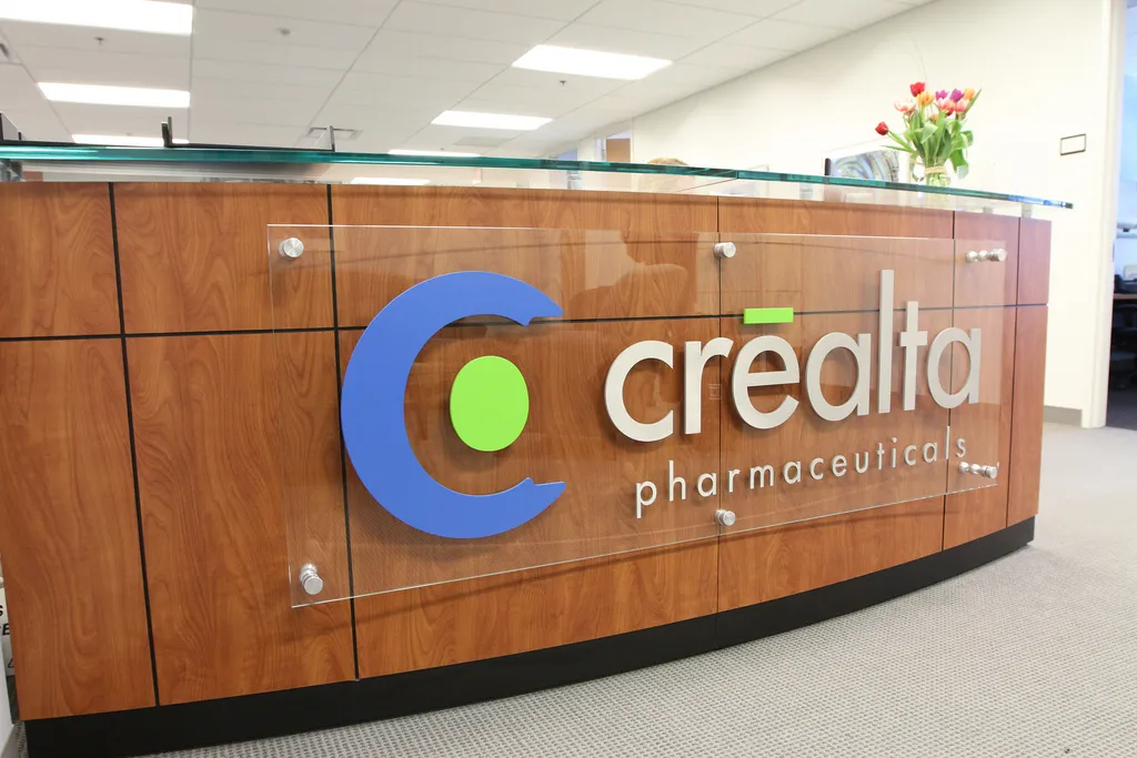 An acrylic board sign with 3D letters and logos. Installed on the side of an office reception desk with metal stand offs.